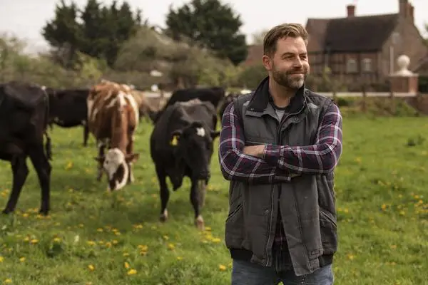Cows grazing and smiling farmer